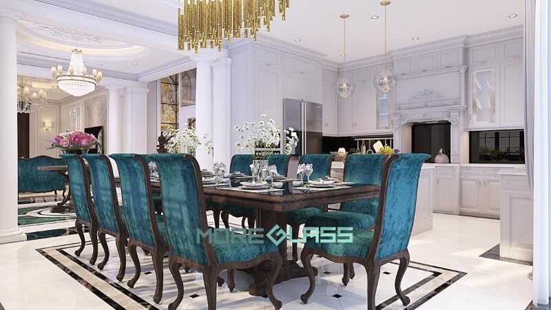 Thiết kế nội thất phòng bếp liền phòng ăn mang phong cách hoàng gia với màu trắng là chủ đạo. Điểm nhấn là bộ kính bếp màu đen huyền bí và bộ bàn ghế ăn màu xanh sang trọng. Thiết kế phòng bếp đẹp